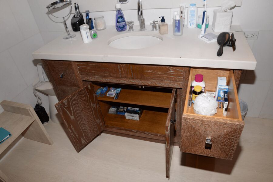 Encimera de un cuarto de baño con cepillos de dientes y artículos de higiene