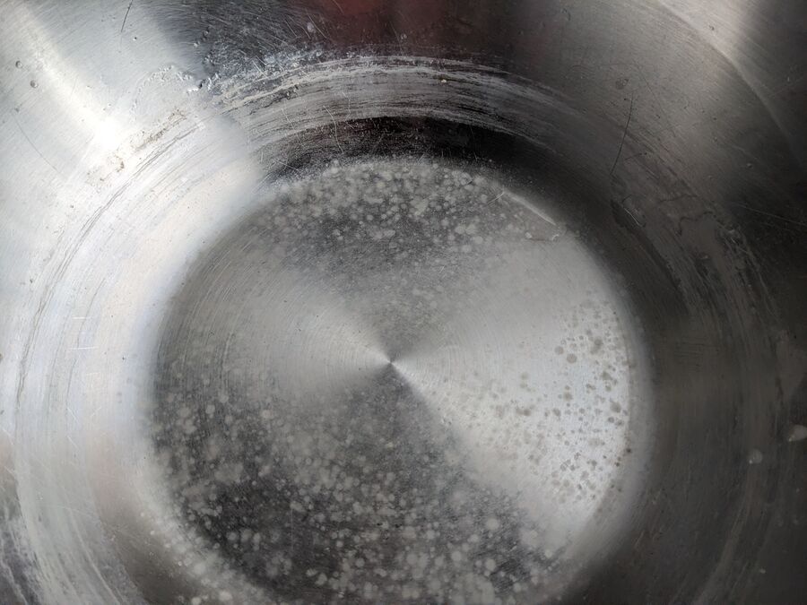 Depósito de cal incrustada en un recipiente metálico