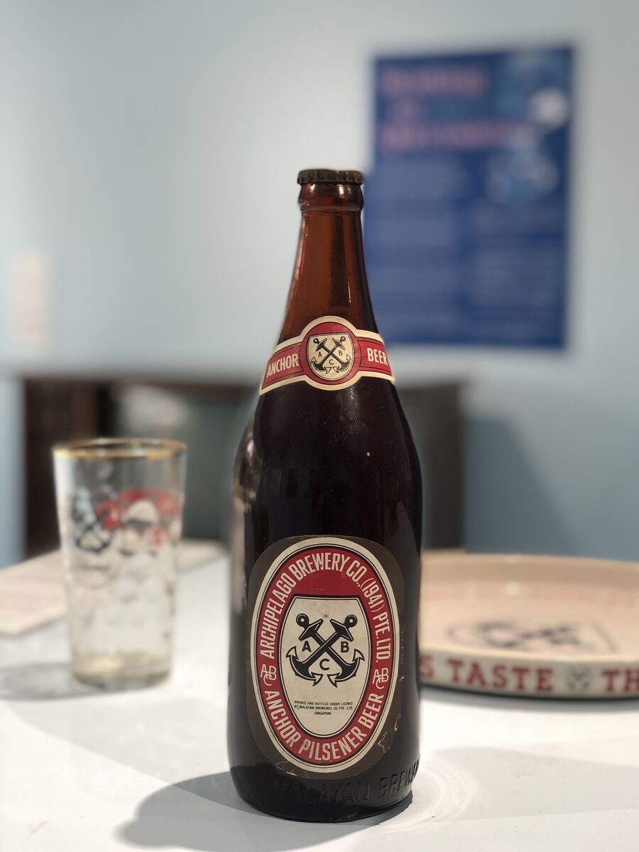Botella de cerveza abierta con su chapa al lado