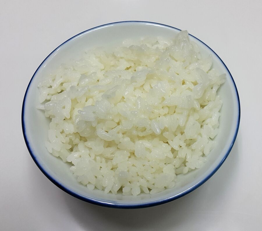 Cuenco de loza con arroz blanco de grano corto ya cocido