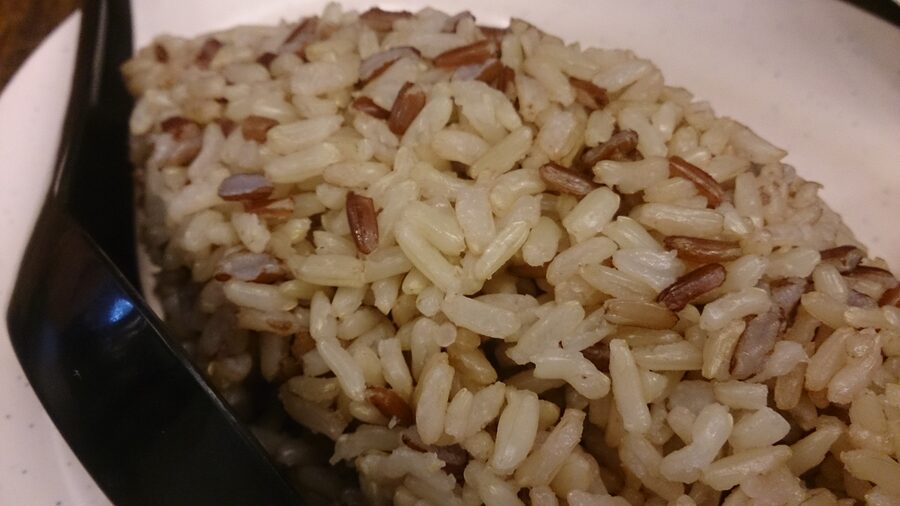 Plato de arroz integral cocido con granos de varios tonos
