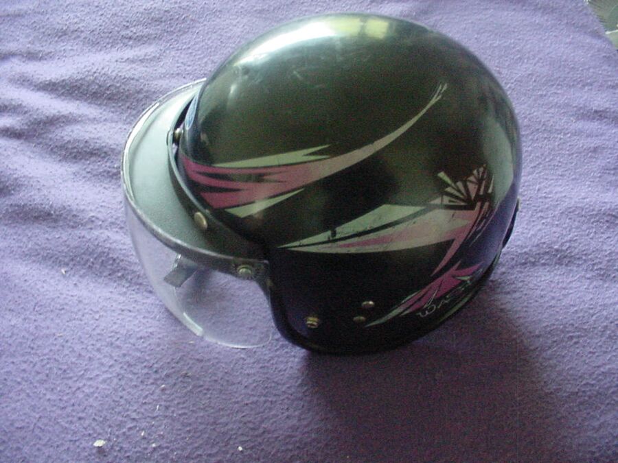Casco de moto integral apoyado, con la pantalla y el acolchado interior a la vista