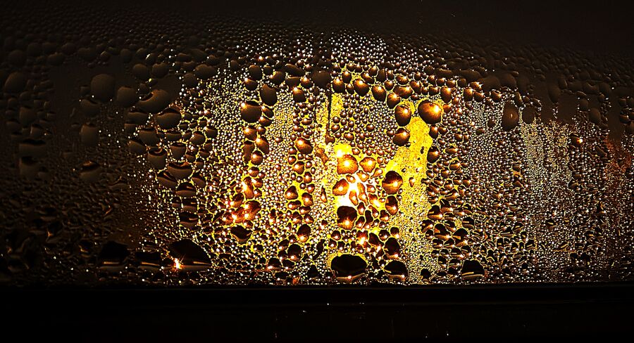 Condensación de agua sobre el cristal de una ventana a contraluz
