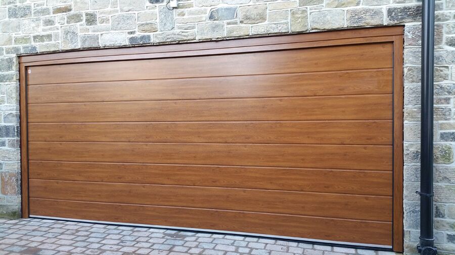 Puerta de garaje seccional de madera abriéndose con mando a distancia