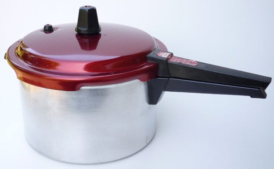 Olla a presión de aluminio con la tapa roja cerrada y la válvula puesta