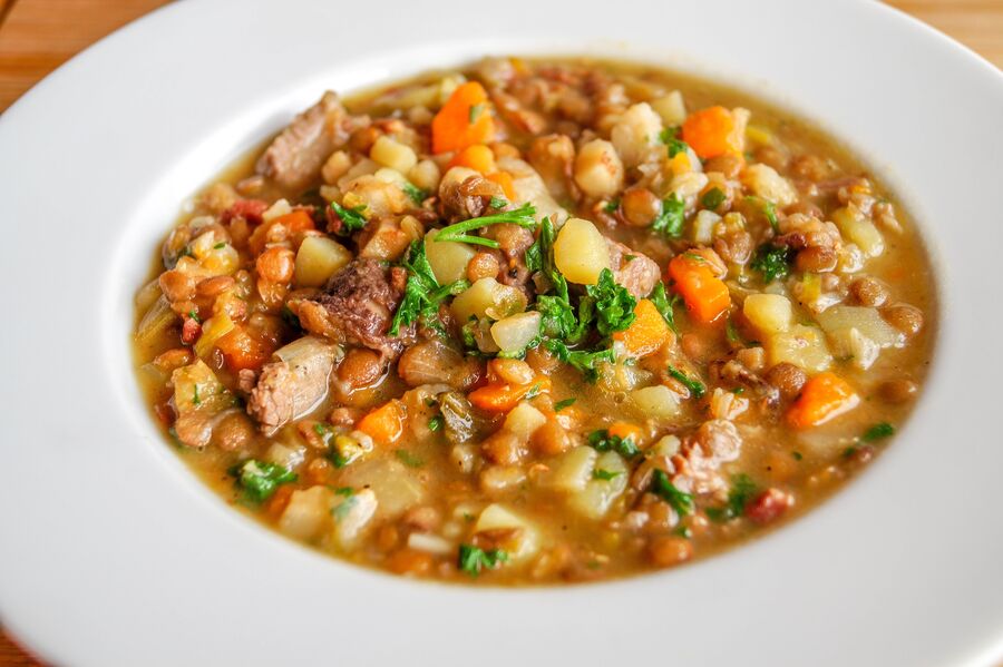 Plato hondo con un guiso de lentejas con patata, zanahoria y carne