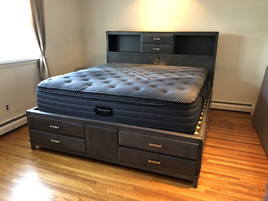 Cama con colchón sobre una base con cajones en un dormitorio